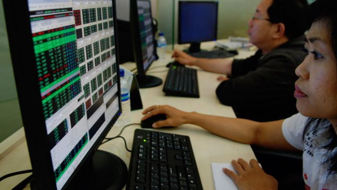 Pialang memantau pergerakan saham.