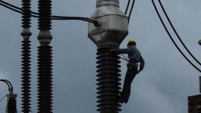 Petugas PLN tengah memperbaiki jaringan listrik di Gardu Induk Gandul, Jakarta.