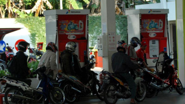 Pengendara motor antre isi bahan bakar di SPBU.