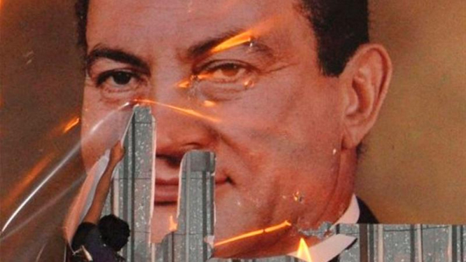 Seorang demonstran di Alexandria merusak poster Presiden Mesir, Hosni Mubarak