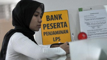 Seorang nasabah melakukan transaksi di bank peserta penjaminan LPS.