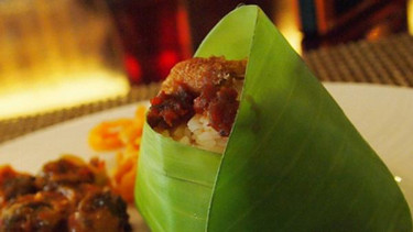 Makanan dibungkus oleh daun pisang.