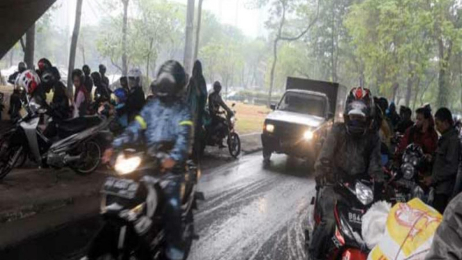 Pengendara Motor yang Berteduh Saat Hujan