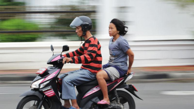 Pengendara memboncengi penumpang tanpa helm.