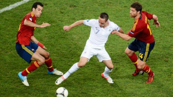 Pemain Prancis, Frank Ribery (putih), diapit pemain Spanyol di Euro 2012
