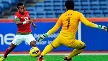 Oktovianus Maniani saat berhadapan dengan kiper Singapura