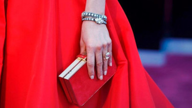 Jennifer Aniston dengan clutch Salvatore Ferragamo