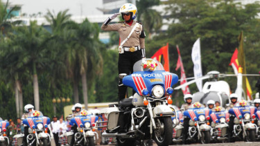 Seorang polisi beratraksi di atas sepeda motornya beberapa waktu lalu. 