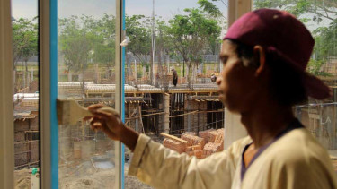 Pekerja melakukan proses pembangunan rumah