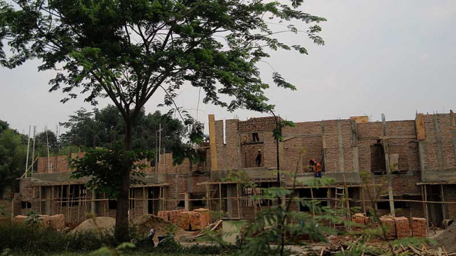 Pekerja menyelesaikan proses pembangunan rumah