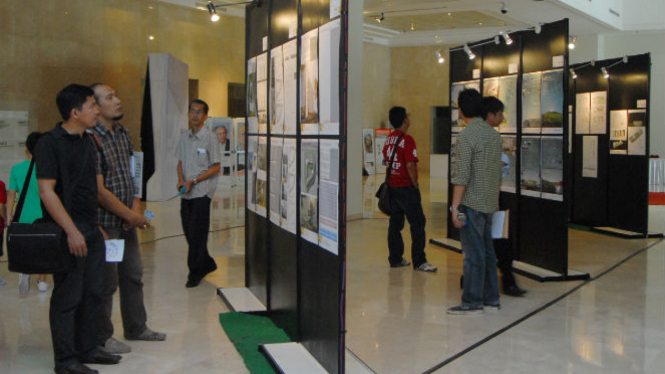 Sejumlah orang sedang melihat galeri pameran di lobby.