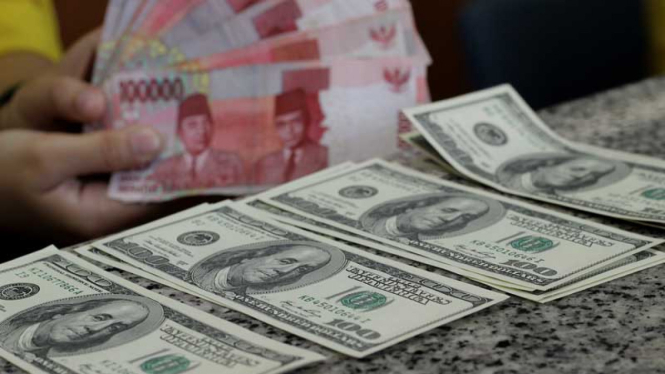 Mata uang rupiah dan dolar AS.