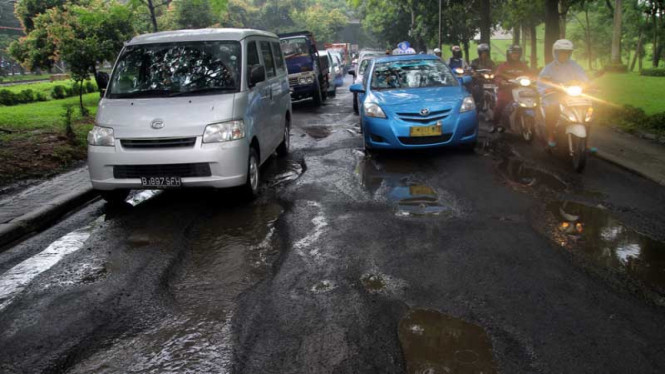 Jalan berlubang di Akses UI, Depok.