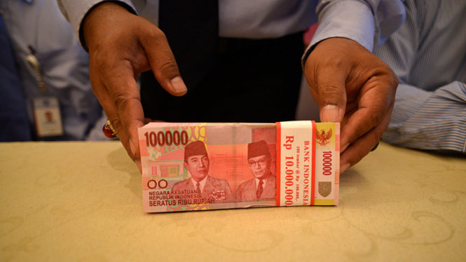 Polisi menunjukkan sejumlah uang dari kasus penipuan.