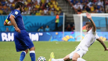 Jack Wilshere (kanan) berebut bola dengan Andrea Pirlo