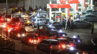 Pengguna kendaraan bermotor antre untuk membeli BBM.