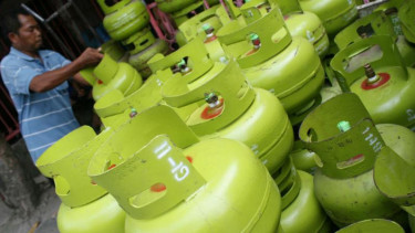 Pekerja menurunkan tabung gas elpiji 3 kg 
