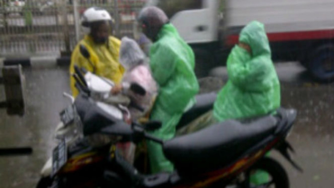 Pesepeda motor kehujanan.