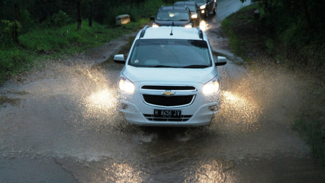 Mobil melintasi genangan air.