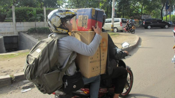 Pemotor membawa barang berukuran besar.