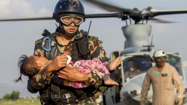 Tentara Nepal menggendong balita yang terluka akibat gempa susulan.