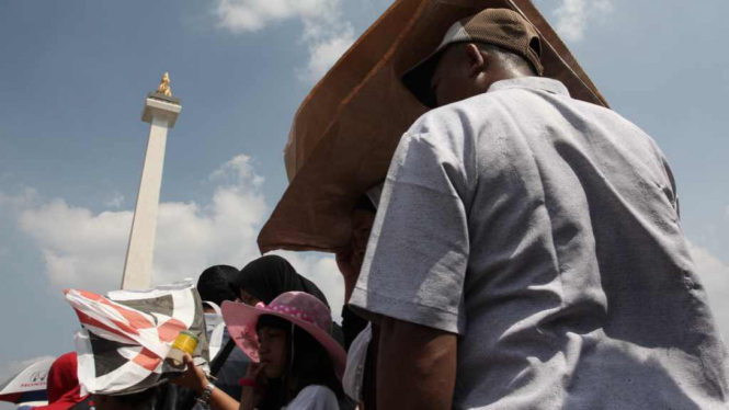 Para pengunjung Monumen Nasional di tengah cuaca terik beberapa waktu lalu.