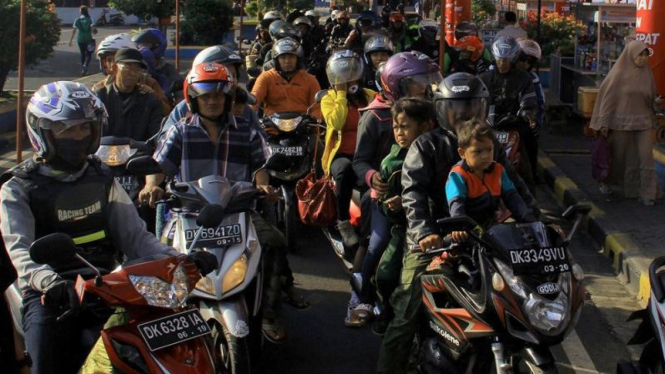 Orangtua bonceng anaknya naik motor.