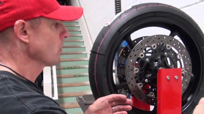 Teknisi sedang melakukan balancing ban motor.