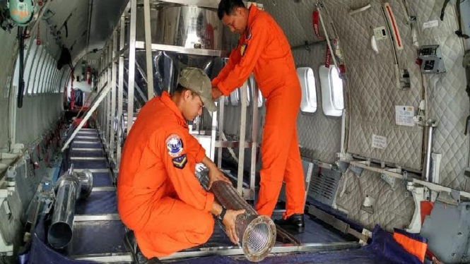 Petugas mempersiapkan hujan buatan dari dalam pesawat terbang beberapa waktu lalu.