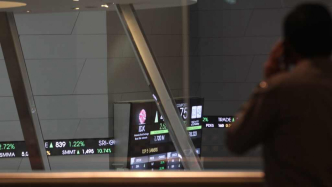 Seorang karyawan BEI mengamati layar indek saham di Bursa Efek Indonesia (BEI)