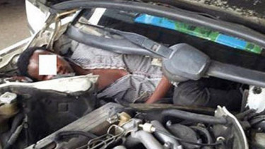 Imigran yang sembunyi di balik kap mesin mobil.