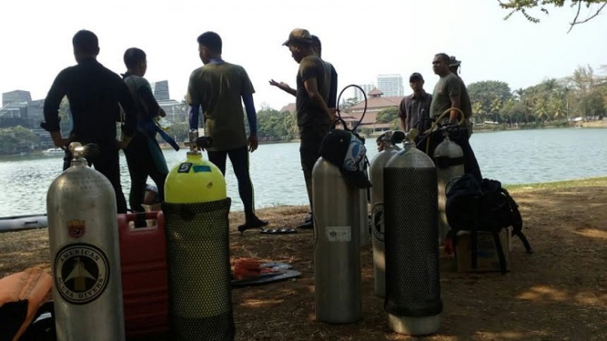 Petugas kepolisian saat menyelidiki danau yang menjadi lokasi ditemukannya mayat Akseyna, mahasiswa UI pada tahun 2015