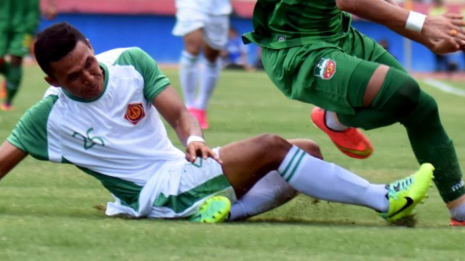 Pemain PS TNI, Wanda Syahputra (kiri) berebut bola.