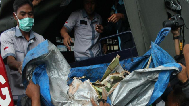 Petugas mengangkut puing-puing pesawat latih tempur Super Tucano