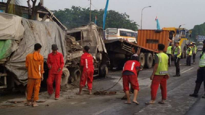 Petugas evakuasi bangkai truk yang terbakar di Tol Cawang.