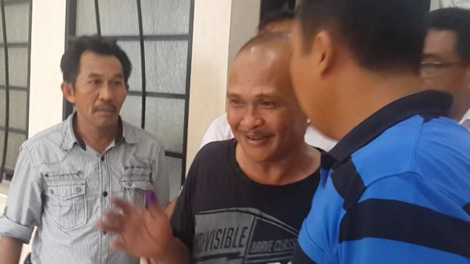 Daeng Azis (berkaos hitam) ketika sedang digiring menuju sel tahanan, Sabtu (27/2/2016)
