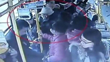 Kakek (bertopi) memarahi seorang wanita yang tak mau memberikan kursinya.