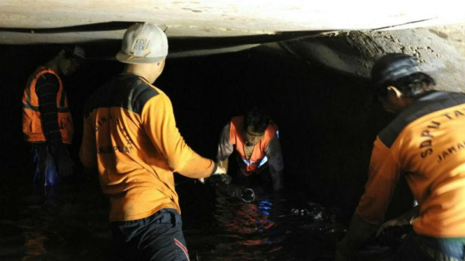 Petugas membersihkan sampah kabel di Jalan Medan Merdeka, Jakarta.