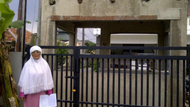 Sri Hari Suwardani di depan rumah yang dibangun pos keamanan.