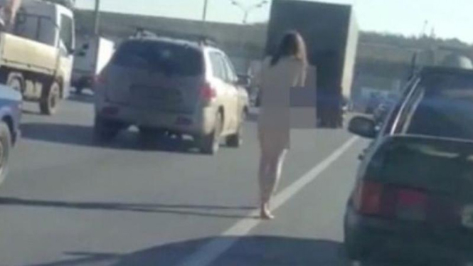 Wanita tanpa busana kedinginan di jalanan.