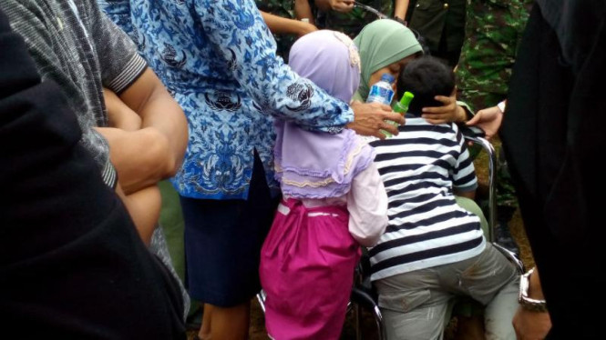 Istri Mayor Cpm Anumerta Agung K. saat memeluk kedua anaknya