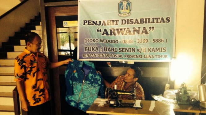 Joko Widodo (kanan-duduk), warga Surabaya penyandang disabilitas, dengan lapak menjahitnya di kantor Dinas Sosial Pemerintah Provinsi Jawa Timur pada Rabu, 23 Maret 2016.