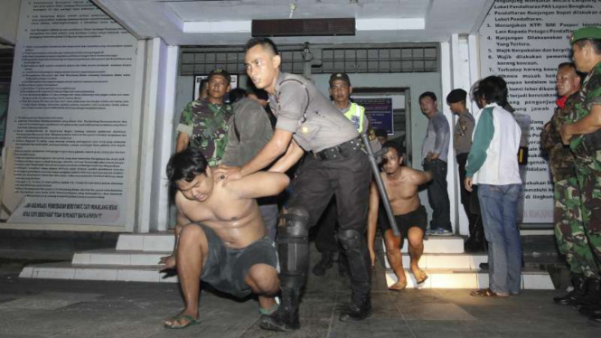 Petugas gabungan TNI dan POLRI mengevakuasi tahanan saat kebakaran yang dipicu aksi tawuran dan tembak menembak antar napi di Lembaga Permasyarakatan (Lapas) Kelas II A Malabero Kota Bengkulu, Jumat (25/3/2016)