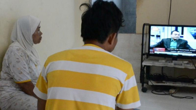 Ibu Wendi Rakhadian (kiri) memantau perkembangan upaya pembebasan anaknya yang disandera kelompok militan Abu Sayyaf melalui siaran televisi di rumahnya pada Kamis, 31 Maret 2016.