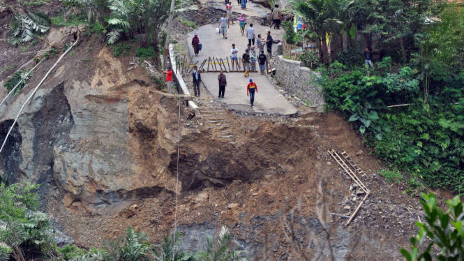 Sejumlah warga menyaksikan jalan raya yang ambles di lokasi bencana longsor di Desa Clapar, Madukara, Banjarnegara, Jateng, Rabu (30/3/2016). 