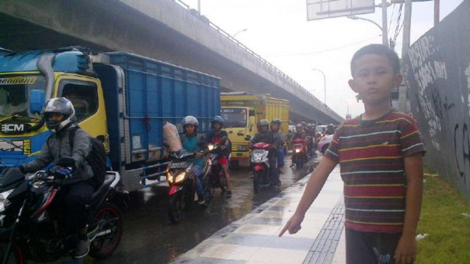 Daffa menghadang pemotor di trotoar jalan.