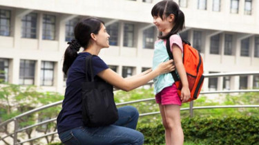 Ibu menemani anak ke tempat sekolah.