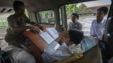 Fitrian (14 tahun), pelajar SMPN 2 Pakem, Sleman, DI Yogyakarta, menjalani Ujian Nasional di dalam mobil ambulans karena mengalami cidera pangkal pinggul akibat kecelakaan pada Senin, 9 Mei 2016.