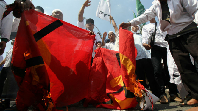 Massa Front Pembela Islam (FPI) dan Front Pancasila membakar kain bersimbol komunis di depan Gedung Negara Grahadi, Surabaya, Jawa Timur, Kamis (28/4/2016).