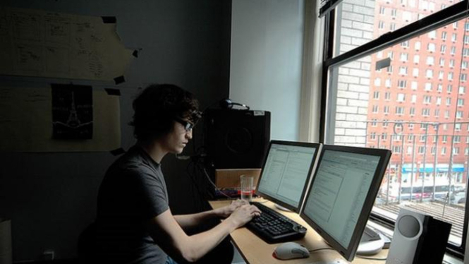 Pria input data di komputer.